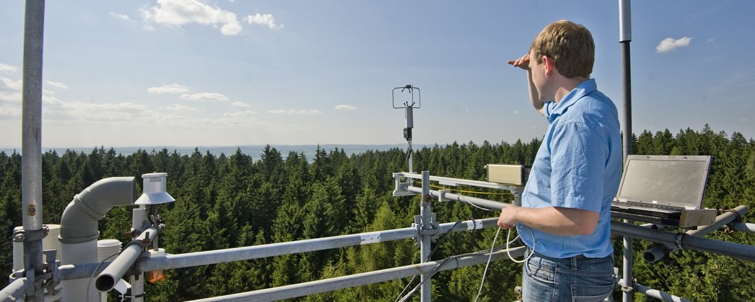 Ein Mann schaut von einer meteorologischen Forschungsstation in die Ferne.